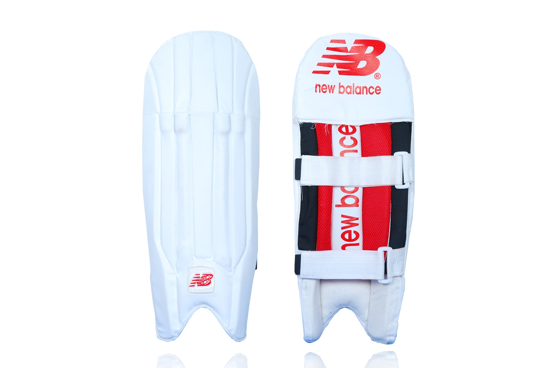 A pair of white New Balance wicket keeping pads with red accents and the brand&
